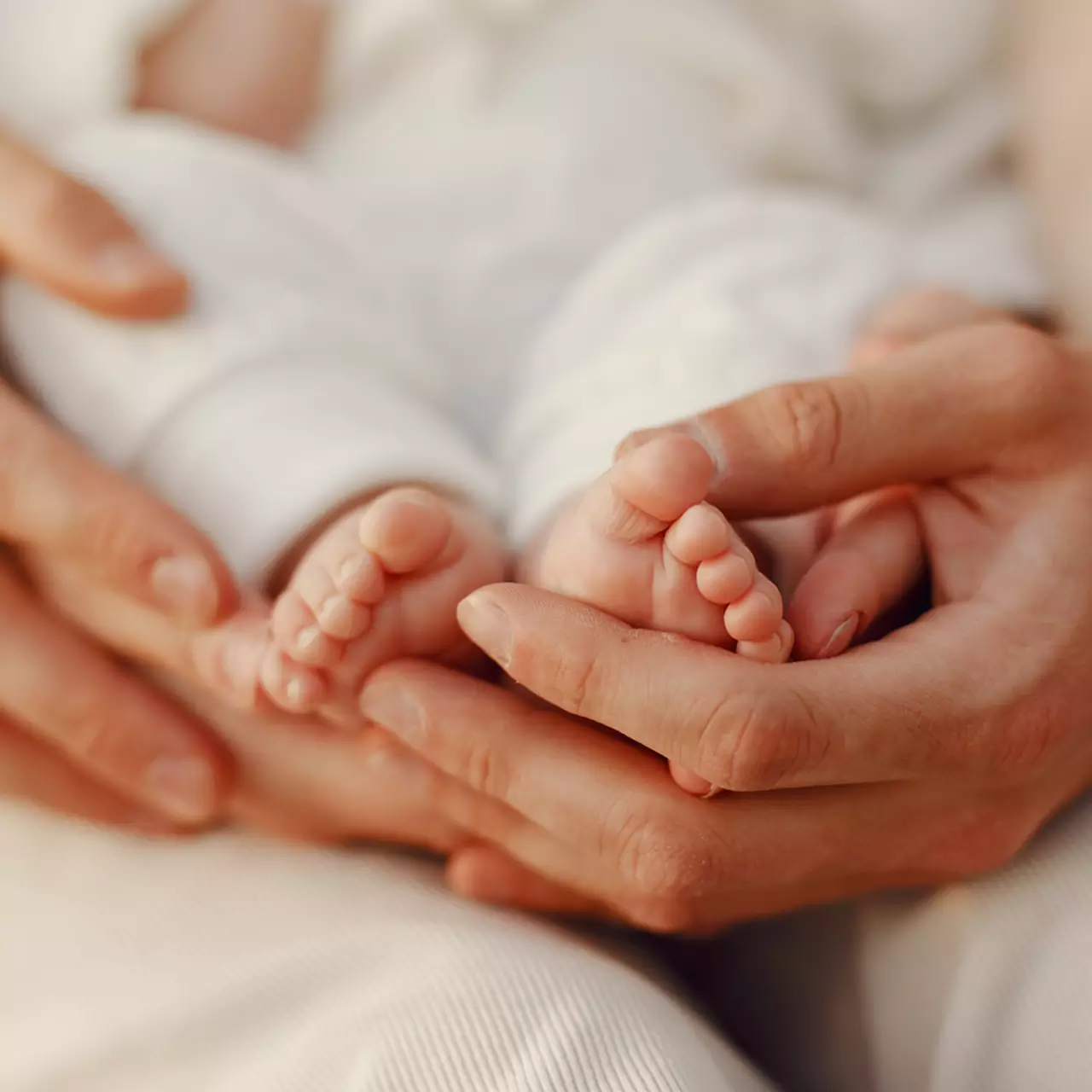 Pieds d'un nourrisson dans les mains de sa maman
