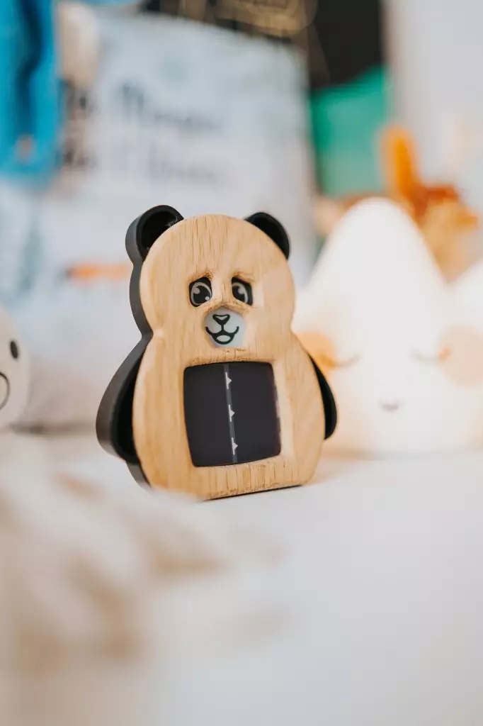 Capteur French Panda posé sur une commode, entouré de peluches et veilleuses
